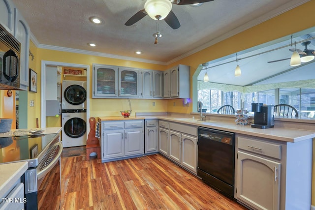 kitchen featuring gray cabinetry, stacked washer and clothes dryer, black appliances, sink, and decorative light fixtures