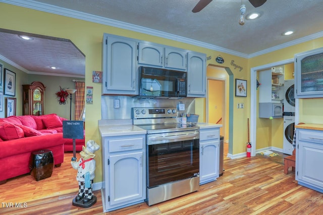 kitchen with stainless steel electric range oven, stacked washer and dryer, light hardwood / wood-style floors, a textured ceiling, and ornamental molding