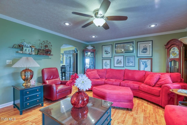 living room with light hardwood / wood-style flooring, ceiling fan, and ornamental molding