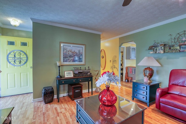 living room featuring crown molding, a textured ceiling, and light wood-type flooring