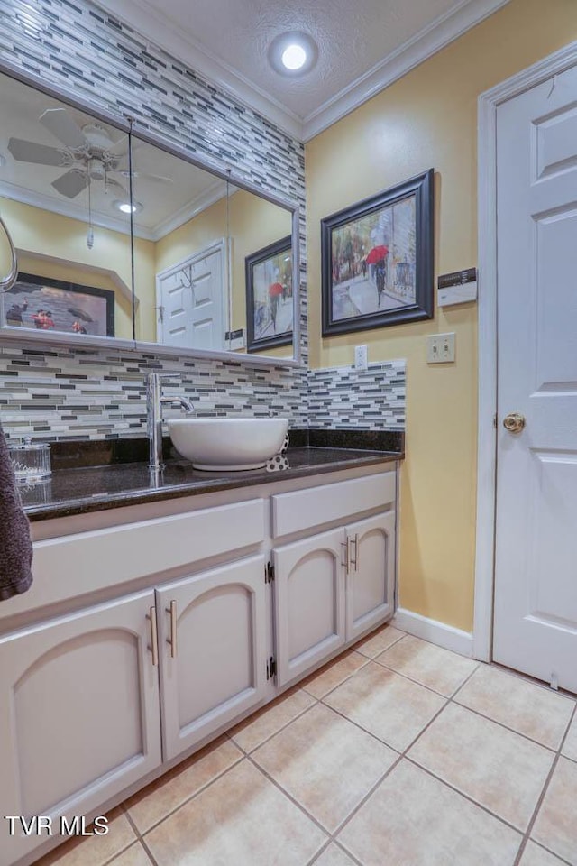 bathroom featuring backsplash, tile patterned floors, vanity, ceiling fan, and crown molding