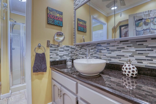 bathroom with tasteful backsplash, tile patterned floors, crown molding, a shower with door, and vanity