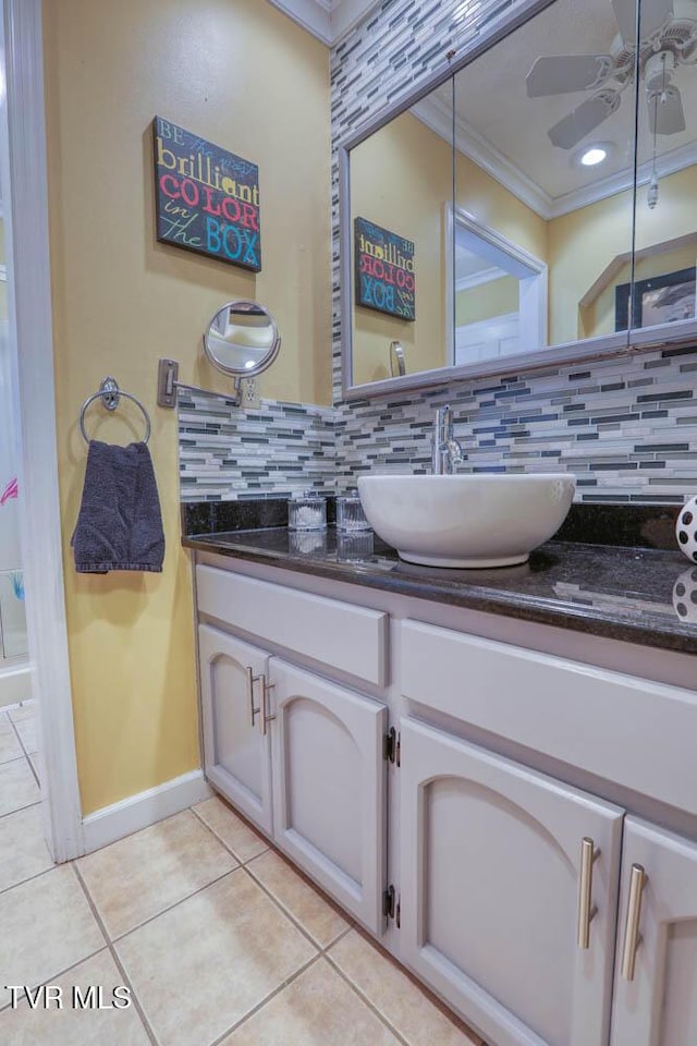 bathroom with tile patterned floors, decorative backsplash, crown molding, and vanity