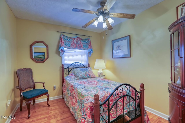 bedroom with ceiling fan and light hardwood / wood-style floors