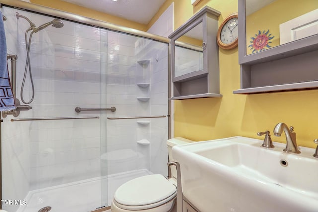 bathroom with an enclosed shower, toilet, and sink