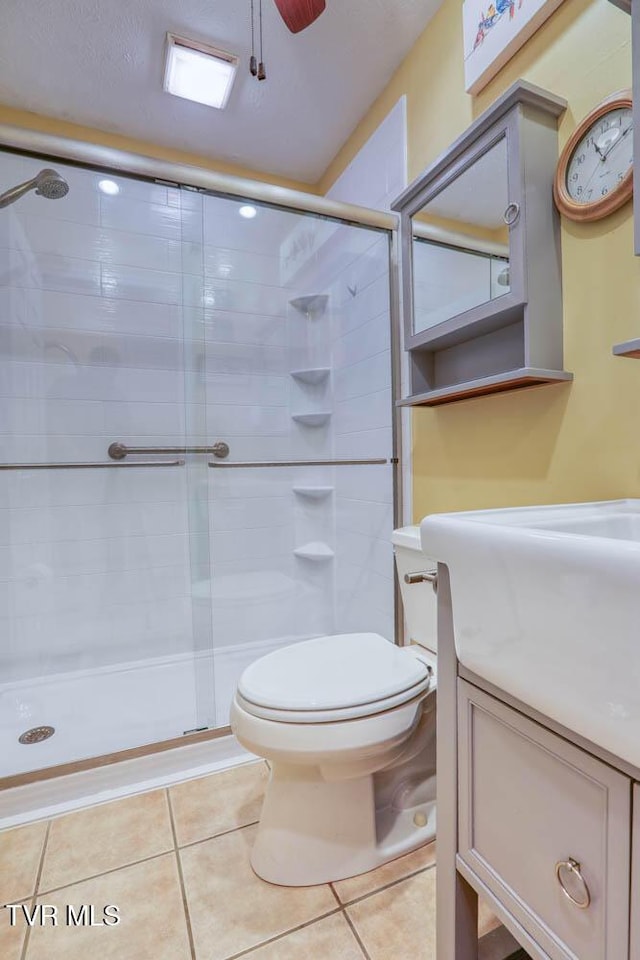 bathroom with toilet, tile patterned floors, and walk in shower