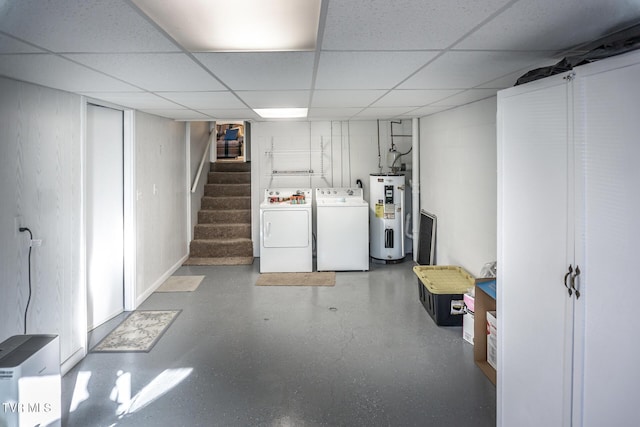 basement with water heater, a drop ceiling, and independent washer and dryer