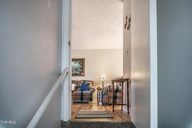 stairs with hardwood / wood-style floors and a textured ceiling