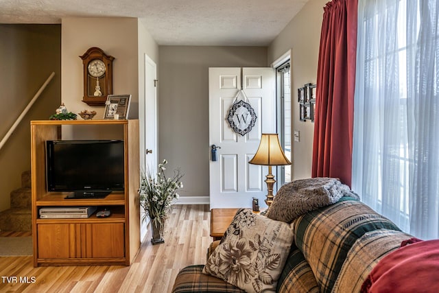 living room featuring light hardwood / wood-style floors and a textured ceiling