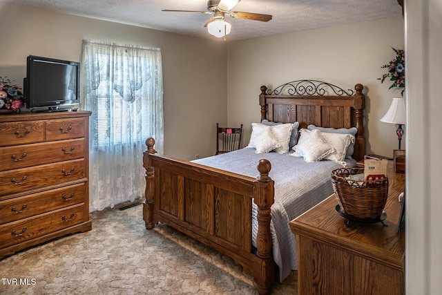 carpeted bedroom with ceiling fan and a textured ceiling