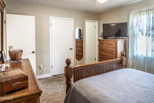 bedroom featuring light carpet and a textured ceiling