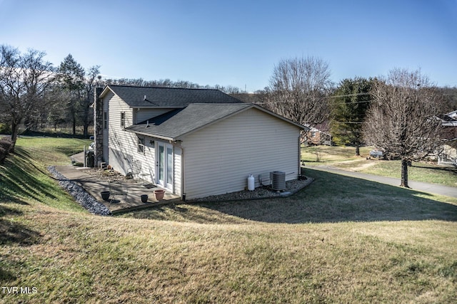 view of side of property featuring a lawn and central air condition unit