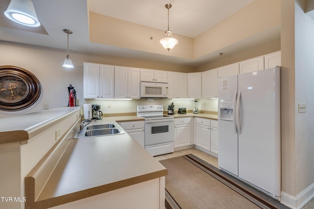 kitchen with white appliances, white cabinetry, hanging light fixtures, and sink