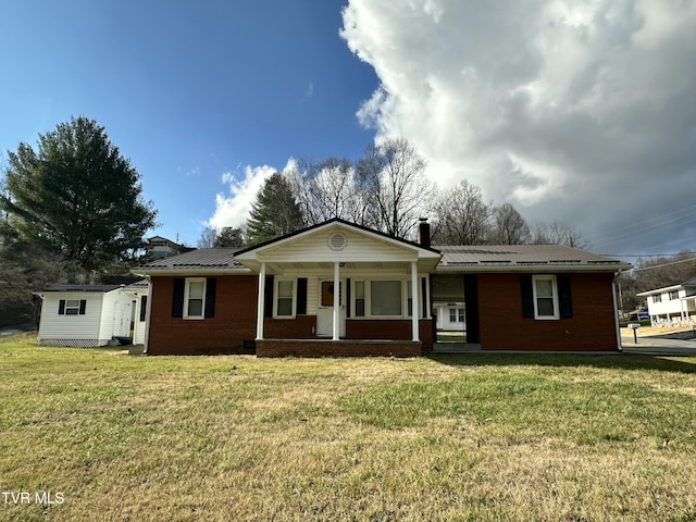 ranch-style house featuring a front lawn and covered porch