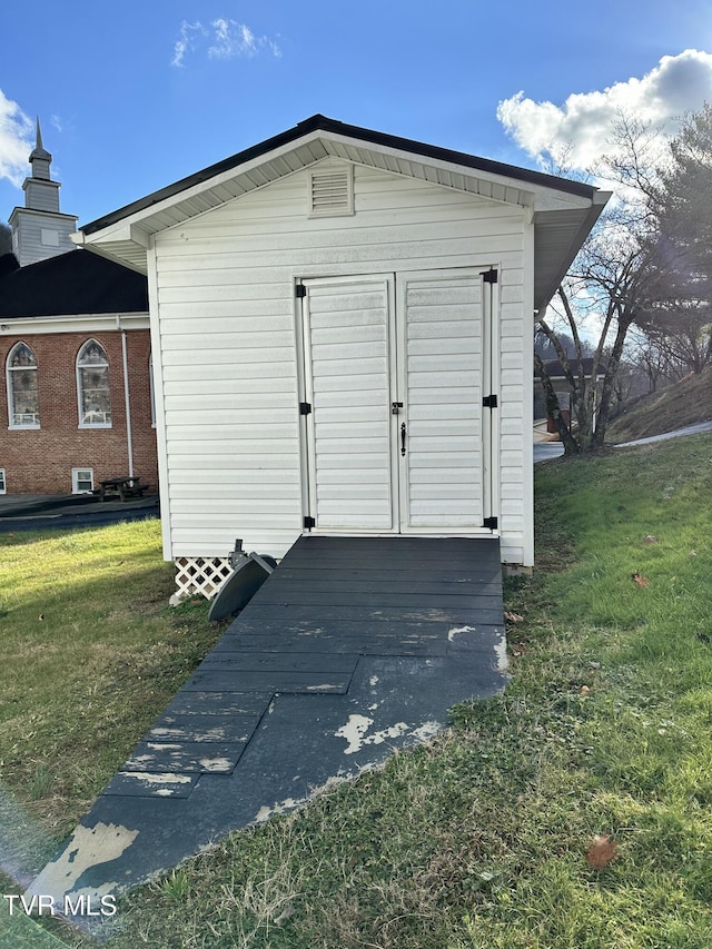 view of outbuilding featuring a lawn