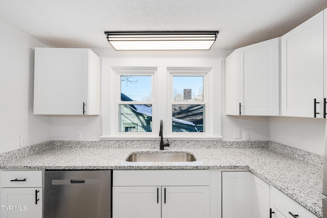 kitchen with light stone countertops, a textured ceiling, dishwasher, white cabinetry, and sink