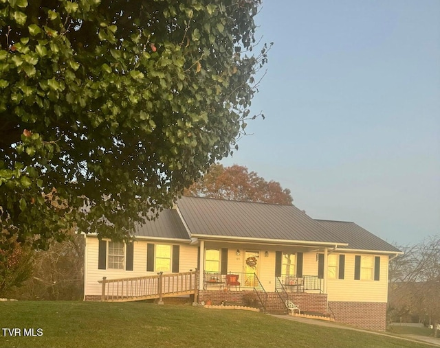 view of front of house featuring covered porch and a front yard