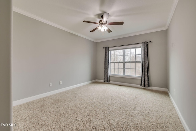 carpeted spare room with ceiling fan and ornamental molding