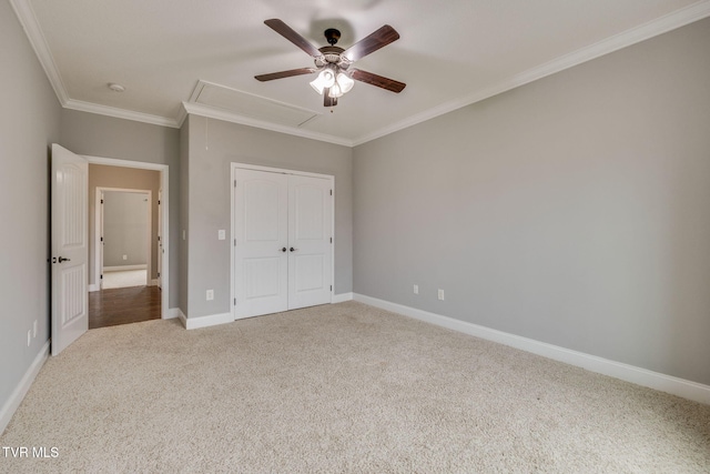 unfurnished bedroom featuring carpet, ceiling fan, crown molding, and a closet