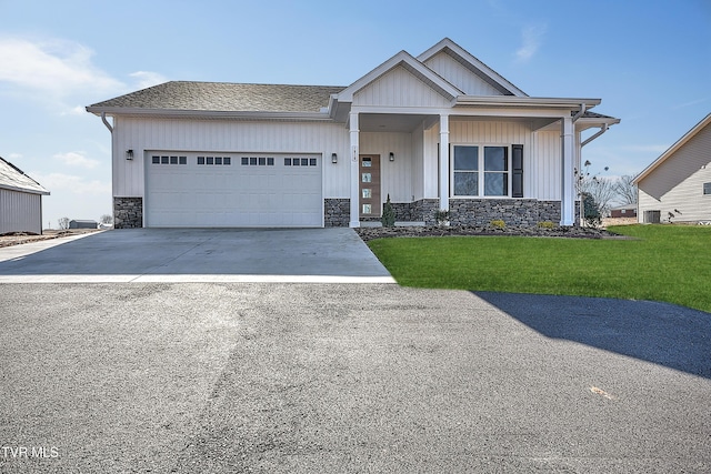 view of front of property featuring a garage, central AC, and a front yard