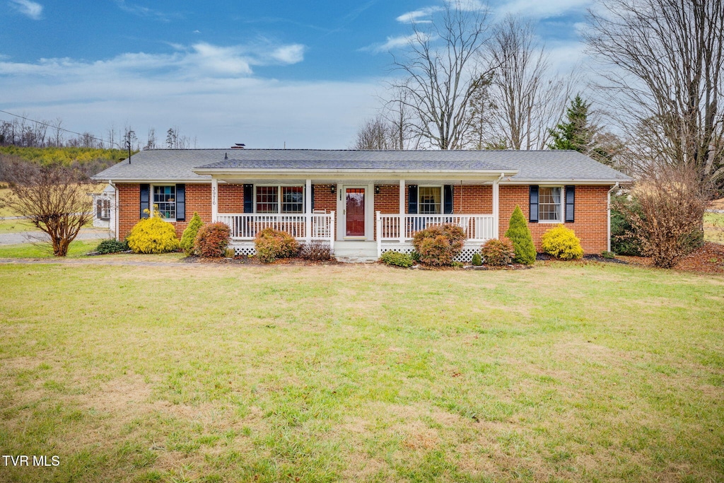 ranch-style home with a front yard and covered porch