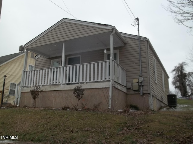 back of house with a porch and a yard