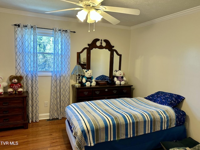 bedroom with hardwood / wood-style floors, a textured ceiling, ceiling fan, and crown molding