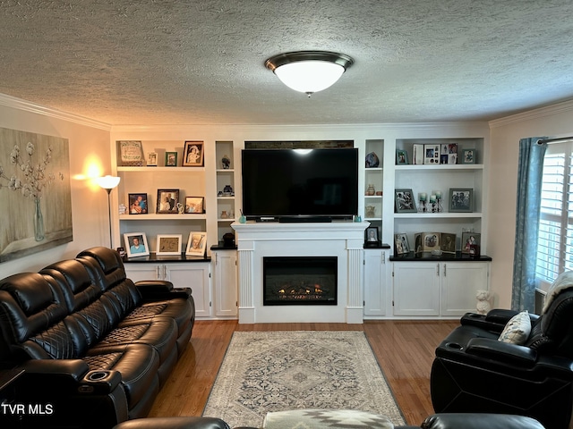 living room featuring built in shelves, crown molding, a textured ceiling, and light hardwood / wood-style flooring