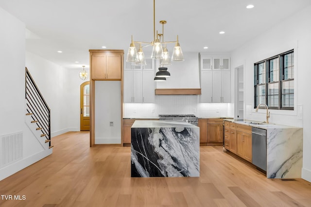 kitchen with white cabinetry, dishwasher, a center island, sink, and decorative light fixtures