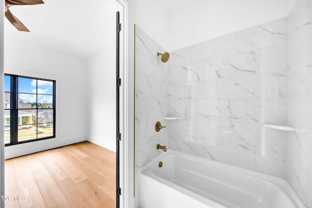 bathroom with hardwood / wood-style floors and tiled shower / bath combo