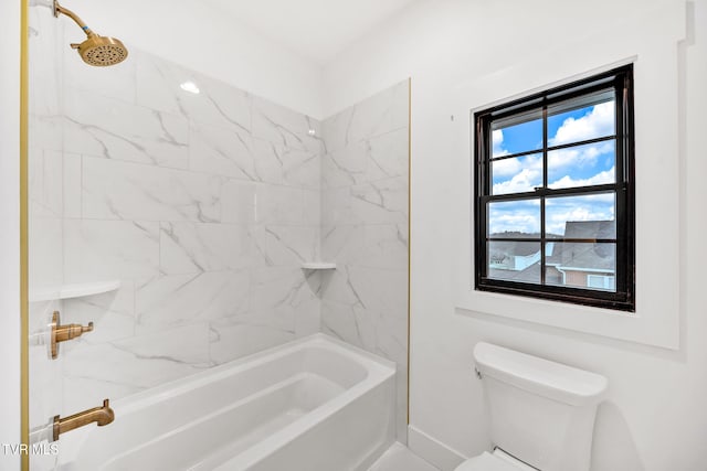 bathroom with toilet, a healthy amount of sunlight, and tiled shower / bath