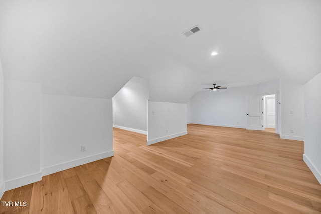 additional living space with light hardwood / wood-style flooring, vaulted ceiling, and ceiling fan