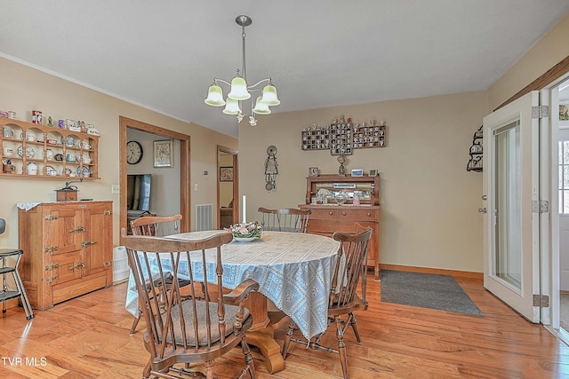 dining room featuring light wood-type flooring and an inviting chandelier