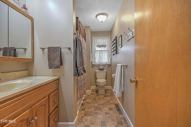 bathroom featuring a textured ceiling, vanity, toilet, and a shower with curtain