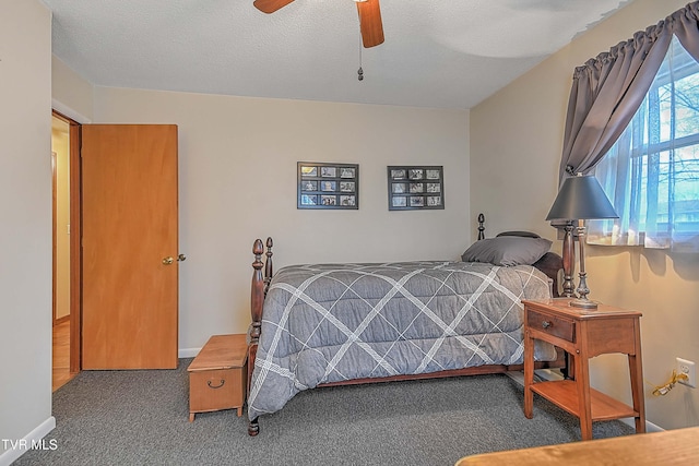 carpeted bedroom featuring ceiling fan and a textured ceiling