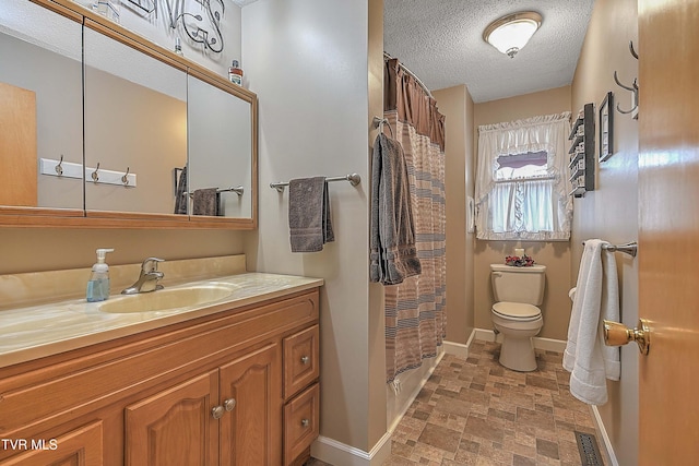 bathroom featuring vanity, toilet, and a textured ceiling