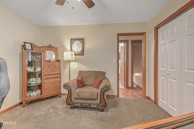 living area with carpet flooring and ceiling fan