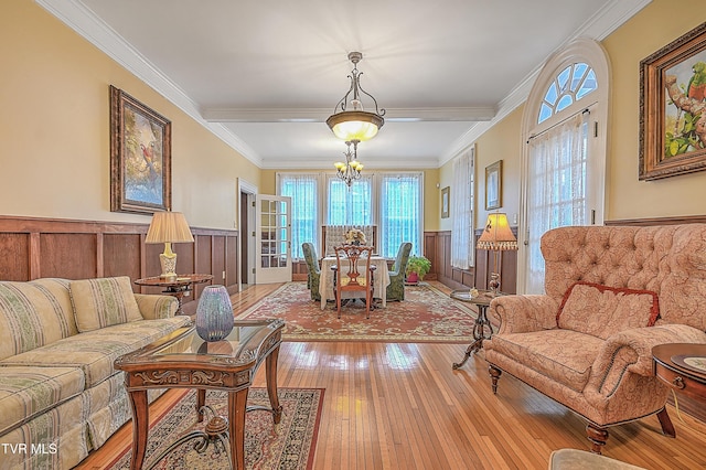 living area with a notable chandelier, hardwood / wood-style flooring, and ornamental molding