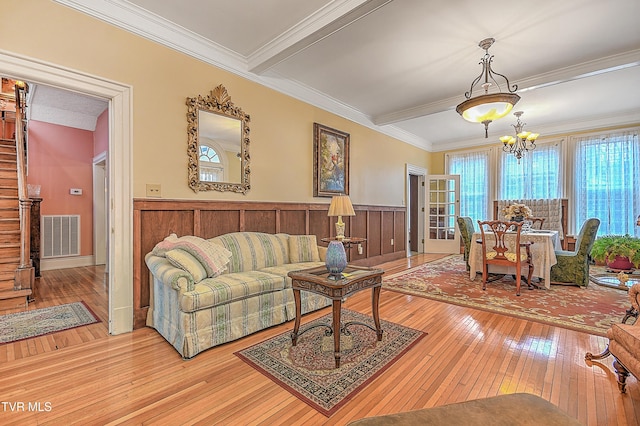 living room featuring ornamental molding, hardwood / wood-style floors, and a notable chandelier