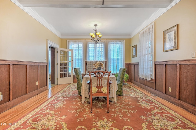 dining room featuring ornamental molding, a chandelier, and light wood-type flooring