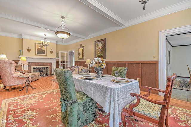 dining room featuring a tile fireplace, wood-type flooring, and crown molding