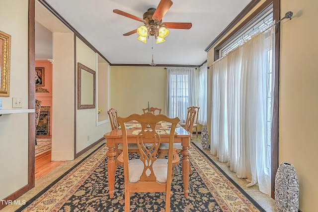 dining space with crown molding and ceiling fan