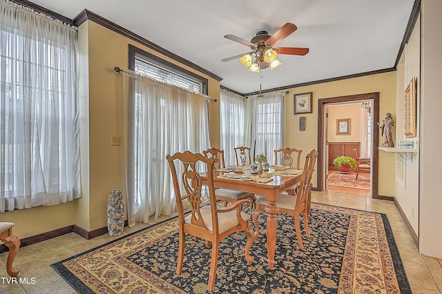 tiled dining room with ceiling fan, ornamental molding, and plenty of natural light