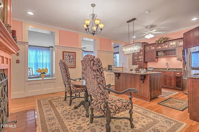 kitchen featuring crown molding, a kitchen bar, a center island, and pendant lighting