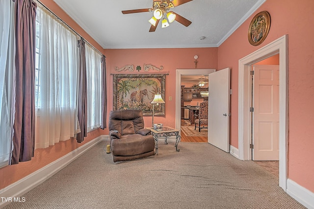 sitting room with crown molding, light carpet, and ceiling fan