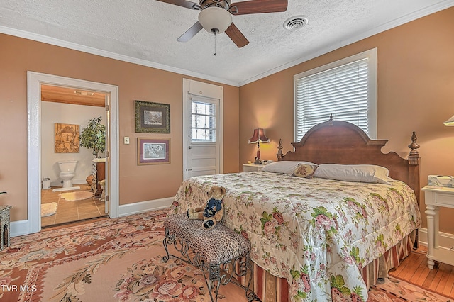 bedroom featuring crown molding, ensuite bathroom, ceiling fan, and a textured ceiling