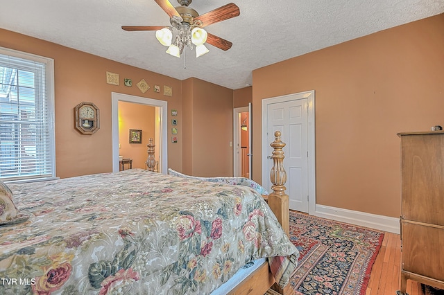 bedroom featuring ceiling fan, wood-type flooring, and a textured ceiling