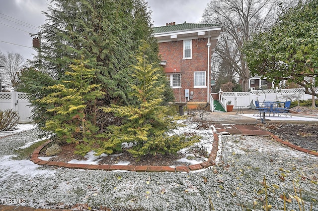 yard layered in snow with a patio area