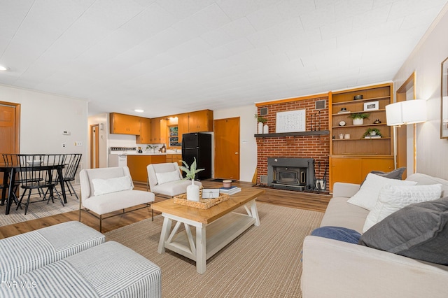 living room with a wood stove, built in features, and light wood-type flooring