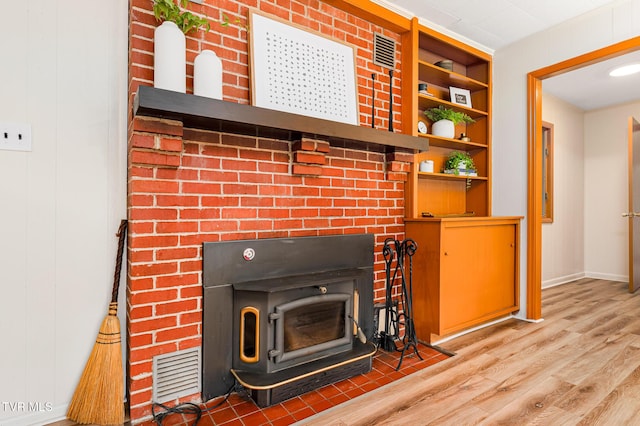 interior details with a wood stove and wood-type flooring